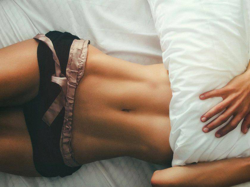 Крошка с плоским животиком фотографирует сексуальное тело на кровати